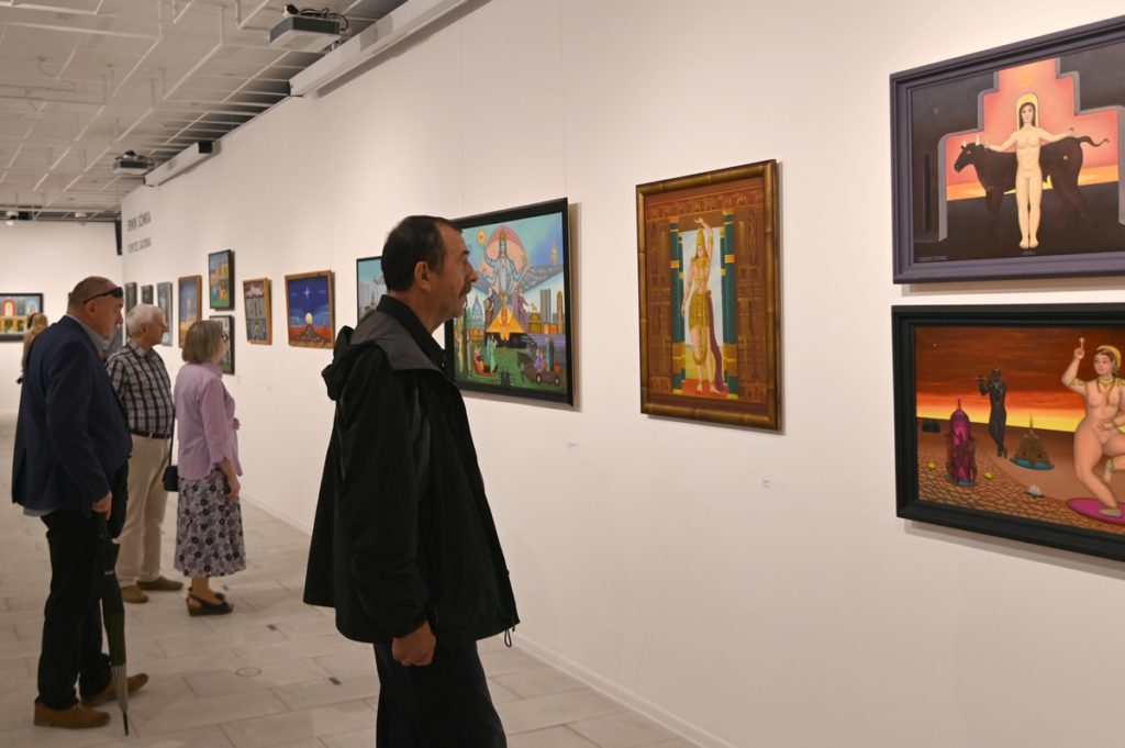 wnętrze galerii, mężczyzna ogląda obrazy Erwina Sówki