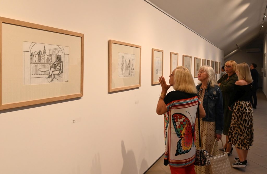 wnętrze galerii, kilka kobiet ogląda obrazy Erwina Sówki