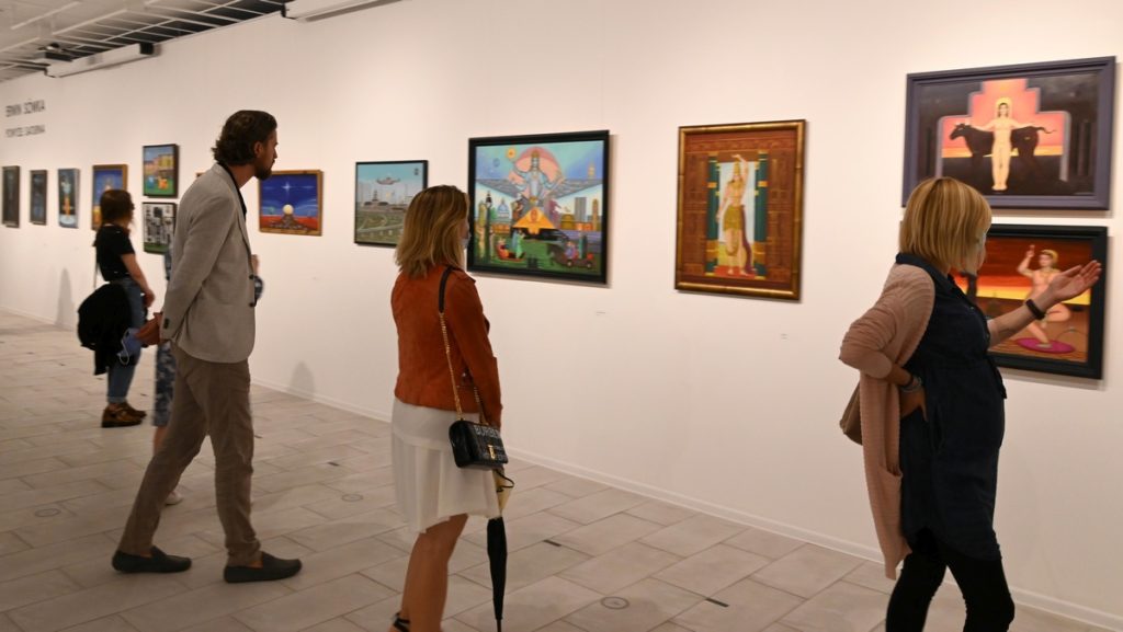 wnętrze galerii, kilka osób z uwagą ogląda obrazy Erwina Sówki