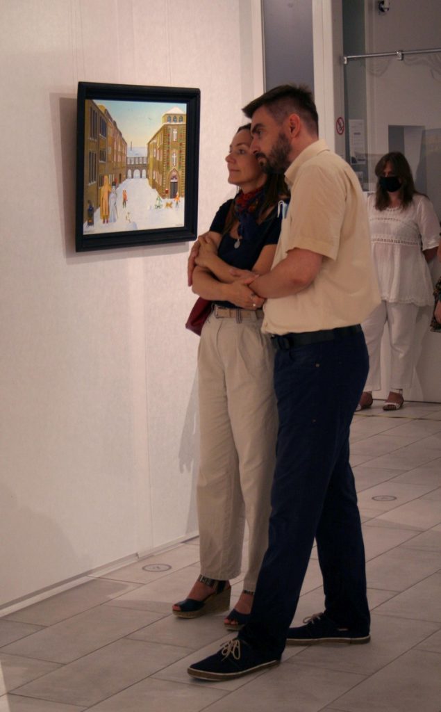 wnętrze galerii, stoją przytuleni do siebie kobieta z mężczyzną i oglądają obraz Erwina Sówki