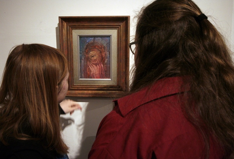 dwie dziewczyny uważnie przyglądają się obrazowi Romana Fleszara