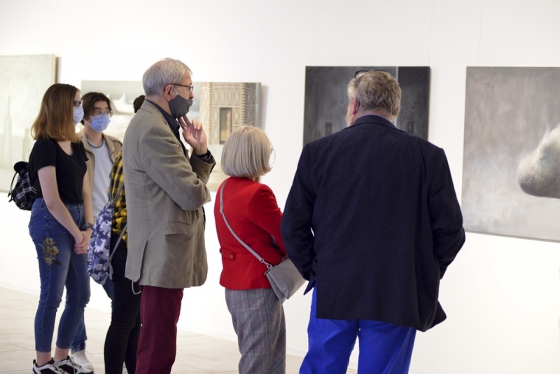 wnętrze galerii, sześć osób przygląda się obrazom Łukasza Huculaka