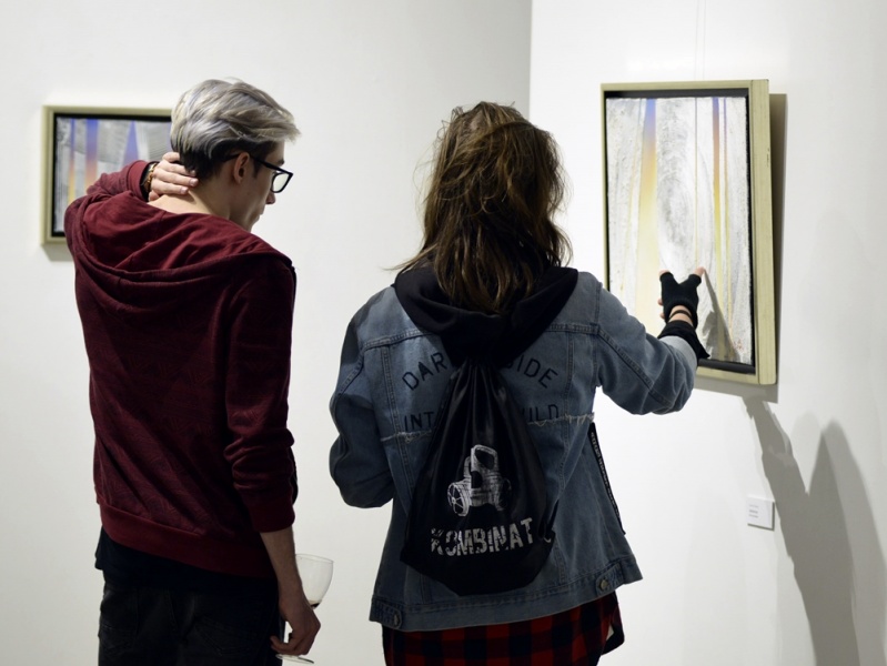 kobieta i mężczyzna oglądają jeden z obrazów Romana Fleszara