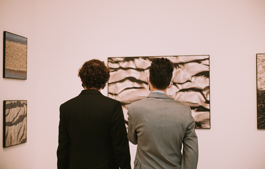 dwóch mężczyzn ogląda jedną z fotogragii, będącej zbliżeniem struktury ziemi