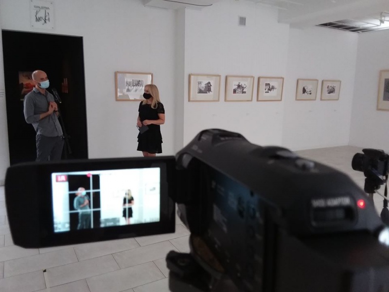 wnętrze galerii, Grzegorz Kozera i Alicja Wasilewska stoją podglądani przez wizjer kamery