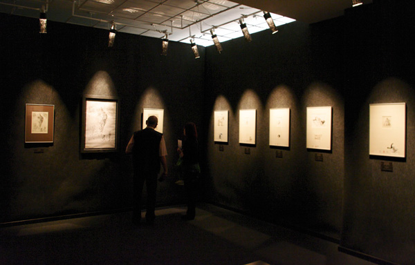 wnętrze Galerii Kreski, mężczyzna ogląda prezentowane grafiki