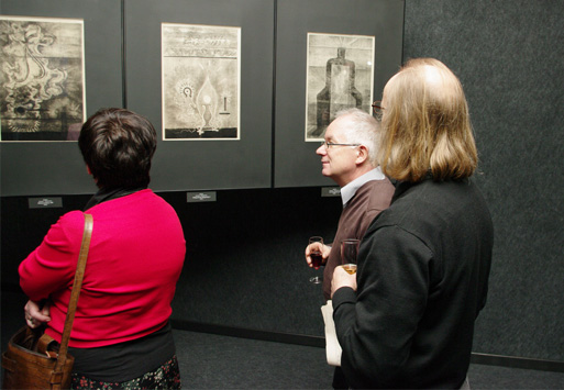 Galeria Kreski, trzy osoby oglądają prezentowane w niej grafiki Janiny Kraupe-Świderskiej