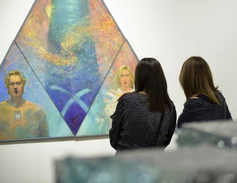 dwie młode kobiety oglądają obraz, mający kształt trójkąta
